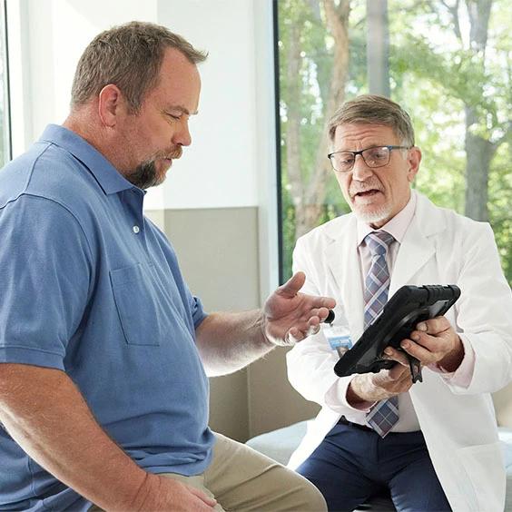 Inspire doctor consulting with patient in a clinical setting using a tablet device